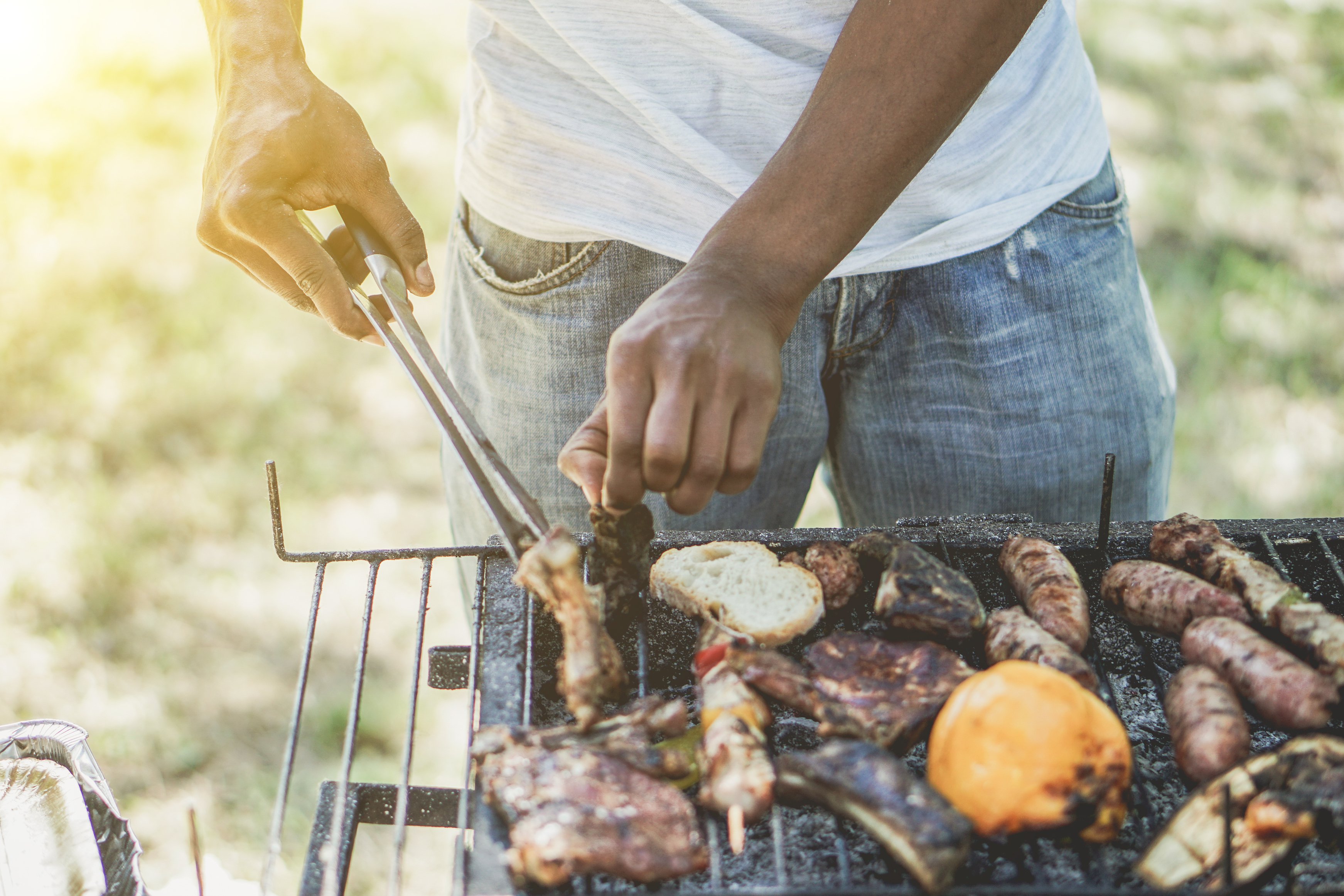 man cooking meat on barbecue